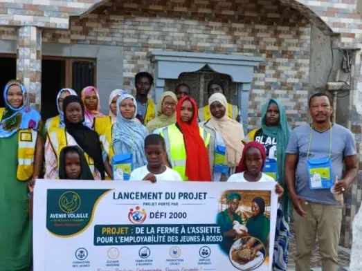 Groupe de jeunes femmes et de jeunes hommes réuni derrière la banderole du projet « De la ferme à l’assiette »