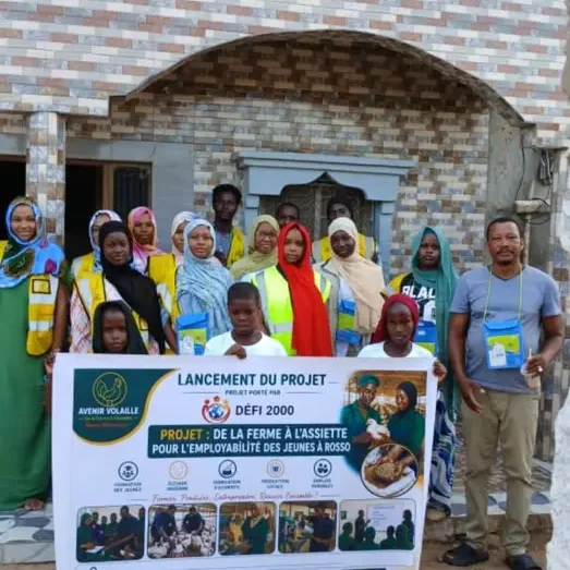 Groupe de jeunes femmes et de jeunes hommes réuni derrière la banderole du projet « De la ferme à l’assiette »