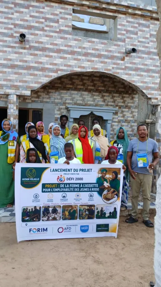 Groupe de jeunes femmes et de jeunes hommes réuni derrière la banderole du projet « De la ferme à l’assiette »